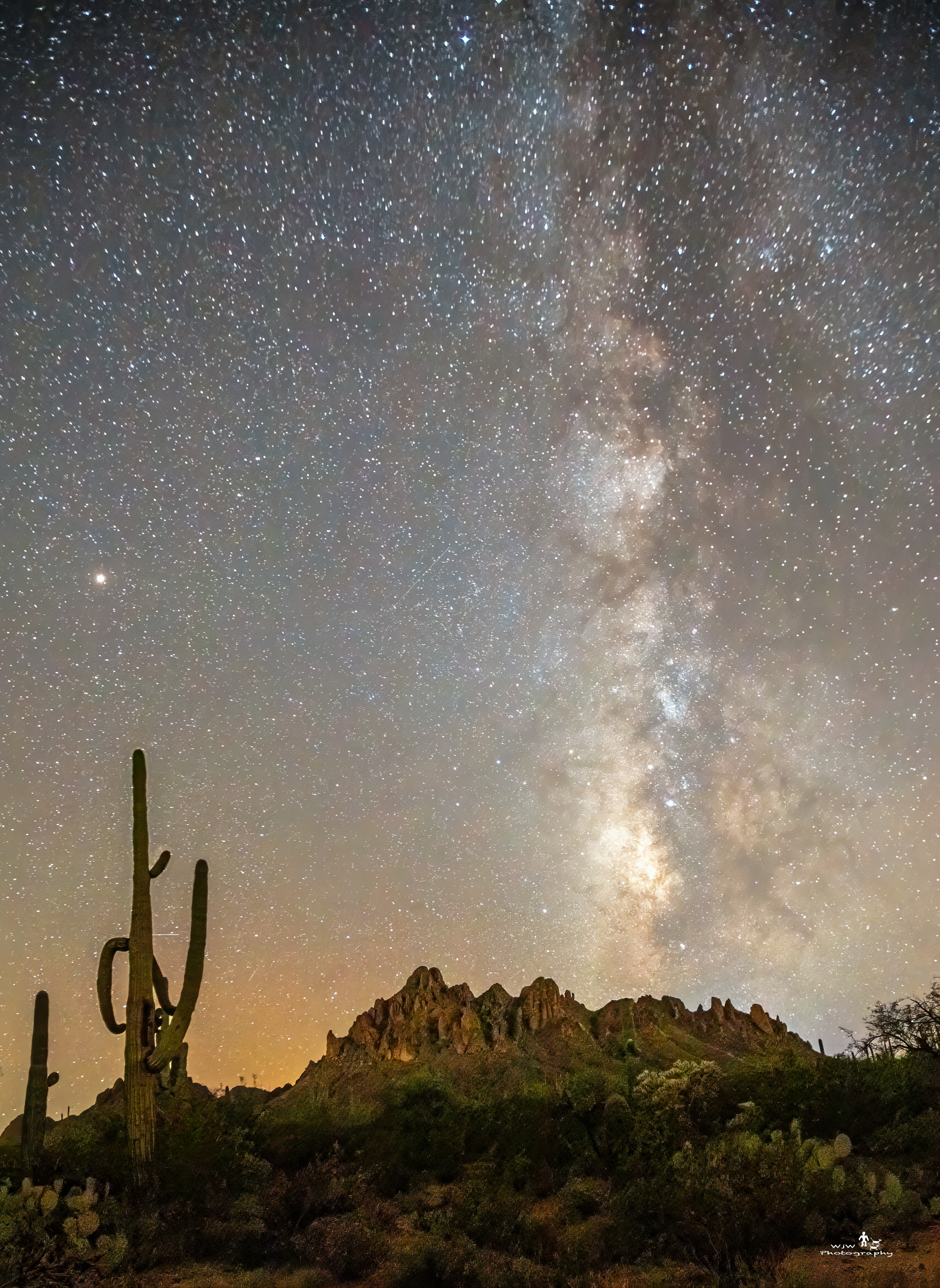 Milky Way rising over rocky desert mountains with saguaro cactus foreground