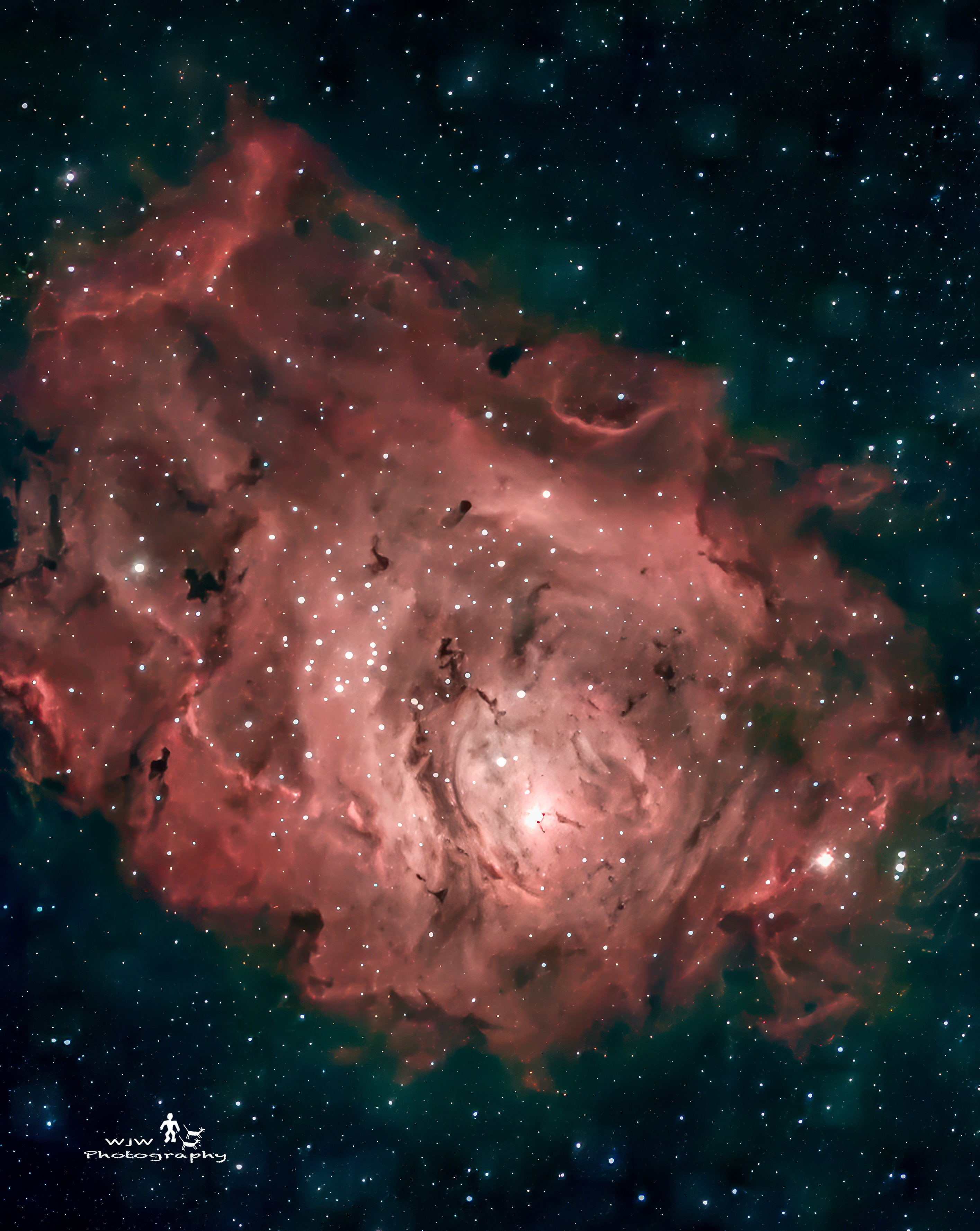 M8 Lagoon Nebula with red and pink gas clouds and stars against teal-dark background