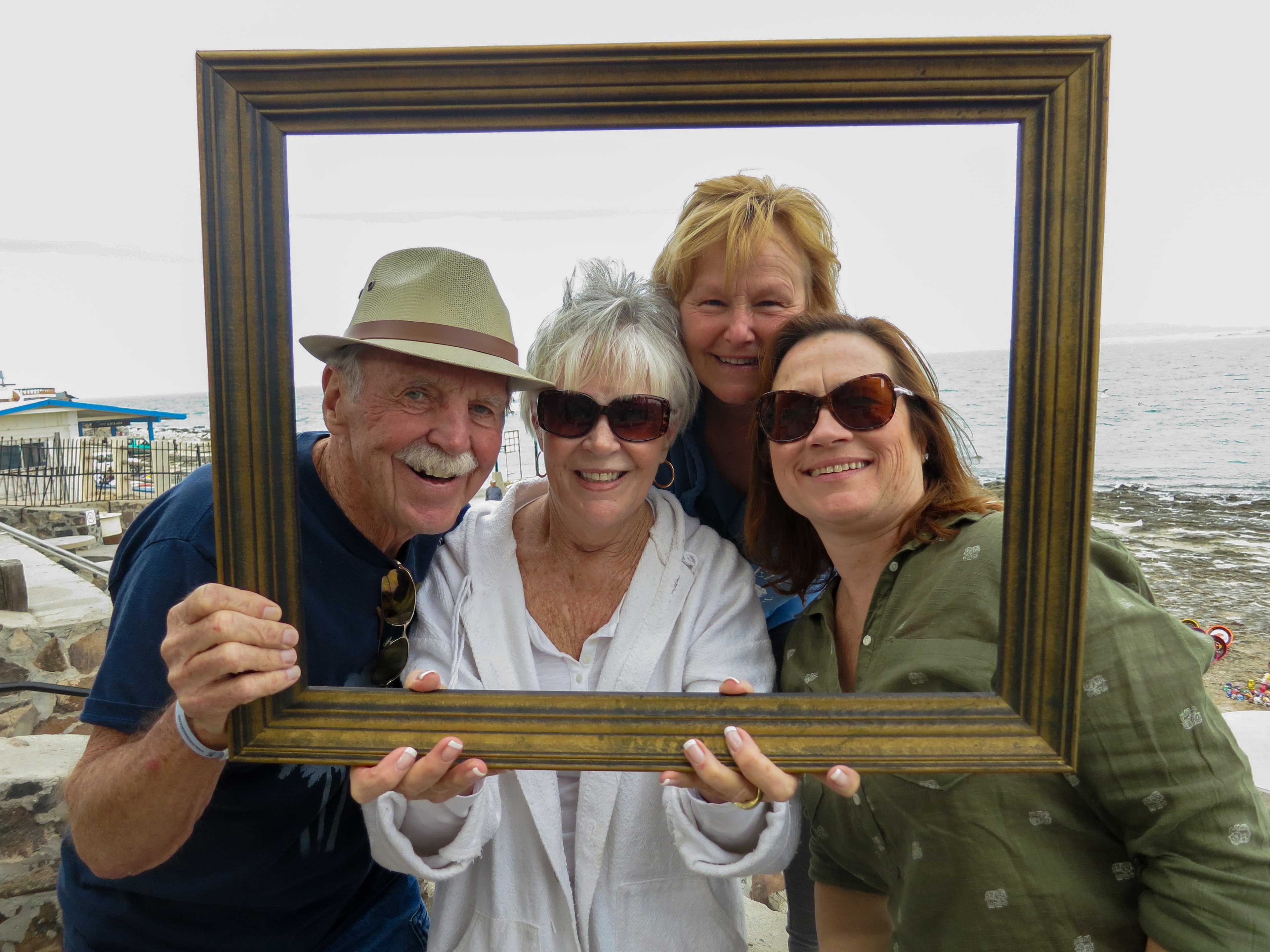 Group of four friends crowding into a picture frame at the Sea of Cortez waterfront