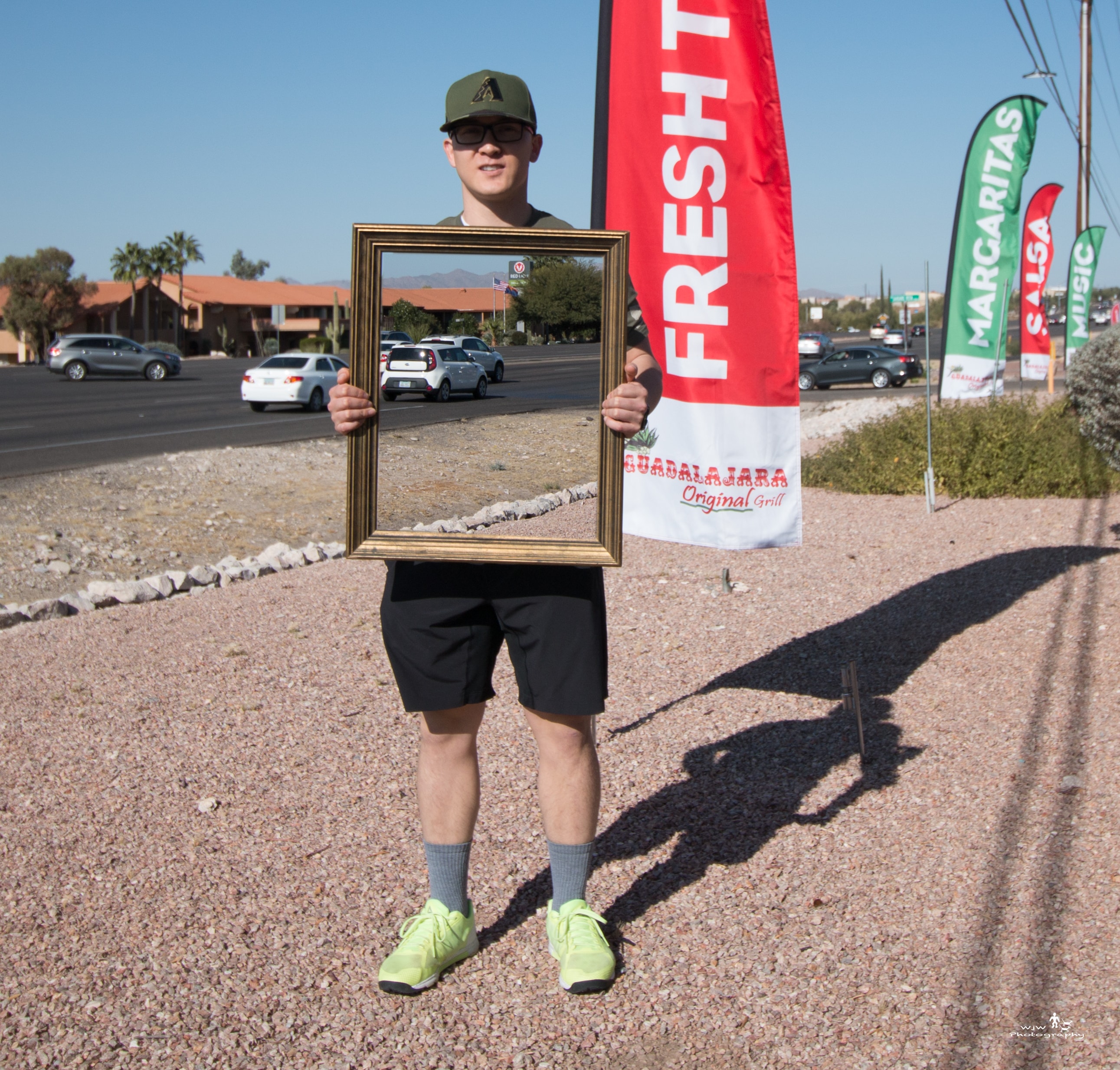 Person holding a gold picture frame outdoors