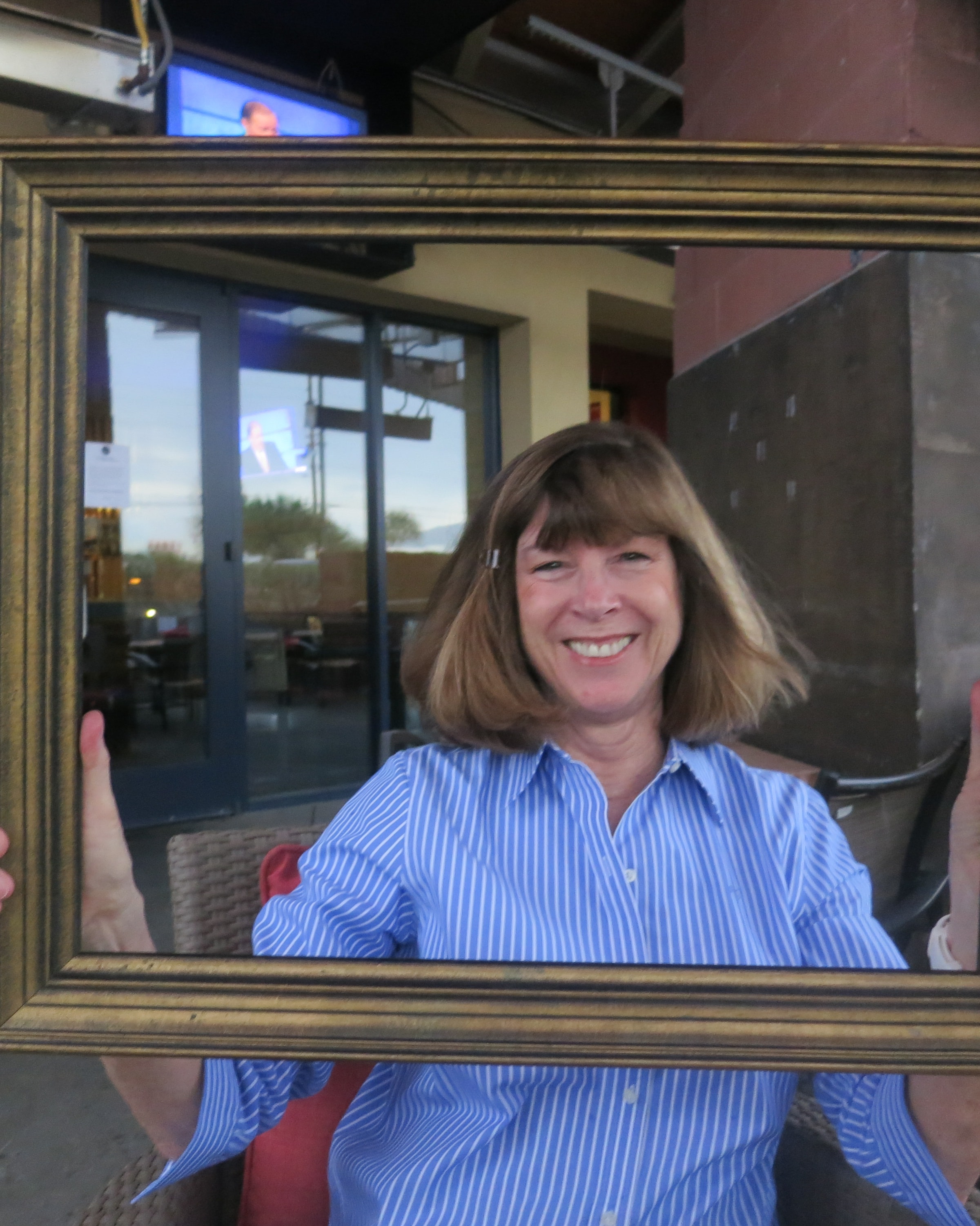 Woman smiling through a decorative gold frame